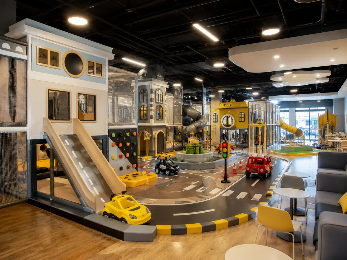 Commercial city role-play indoor playground with mini buildings, road area and child-sized vehicles