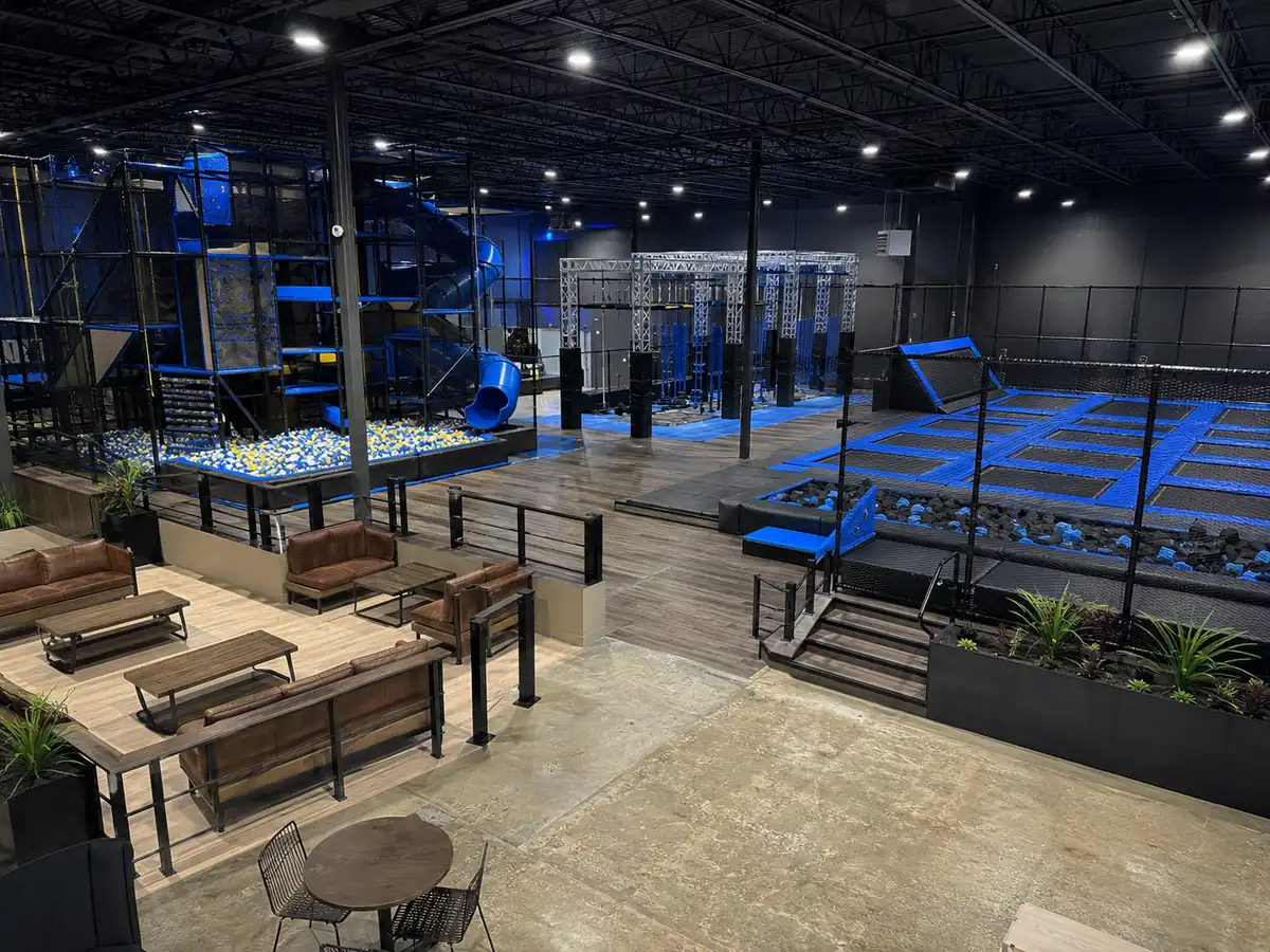 Multi-zone indoor family entertainment center with contained play, trampoline court, ninja area and parent lounge